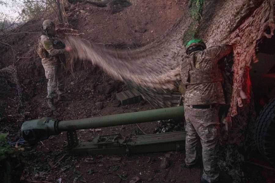 Ukrainian servicemen of Liut brigade camouflage D-30 artillery cannon after firing towards Russian position near Toretsk, Donetsk region, Ukraine, Sunday Sept. 22, 2024. (AP Photo/Evgeniy Maloletka)