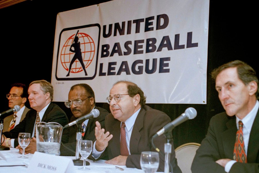 FILE - Agent Dick Moss, second from right, Donald Fehr's predecessor as general counsel of the Major League Players Association, answers a question at a New York news conference, Nov. 1, 1994, announcing the formation of the United Baseball League. From left are Smith College economics professor Andrew Zimbalist; Rep. John Bryant, D-Texas; former major leaguer Curt Flood; Moss, and Robert Mrazek. (AP Photo/Marty Lederhandler, File)