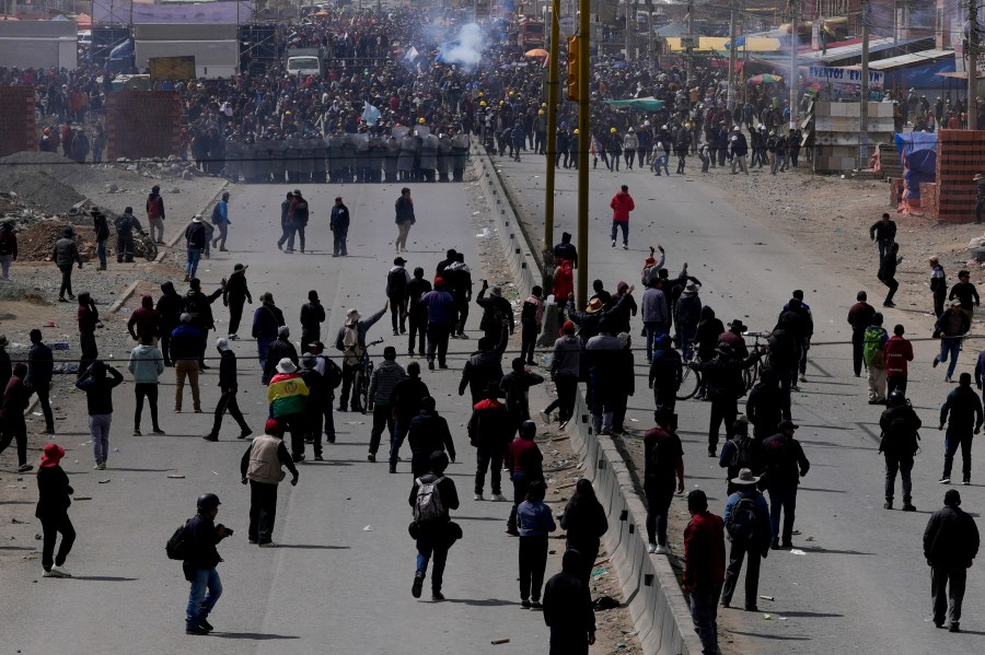 Supporters of former President Evo Morales, below, advance toward supporters of current president Luis Arce in El Alto, Bolivia, Sunday, Sept. 22, 2024. (AP Photo/Juan Karita)