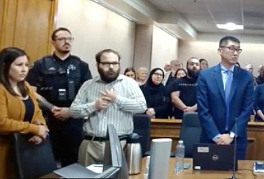 In this image taken from video provided by the Colorado Judicial Branch, Ahmad Alissa, third from left, stands for the verdict in his trial for the 2021 Colorado supermarket shootings, Monday, Sept 23, 2024, in Boulder, Colo. (Colorado Judicial Branch via AP)