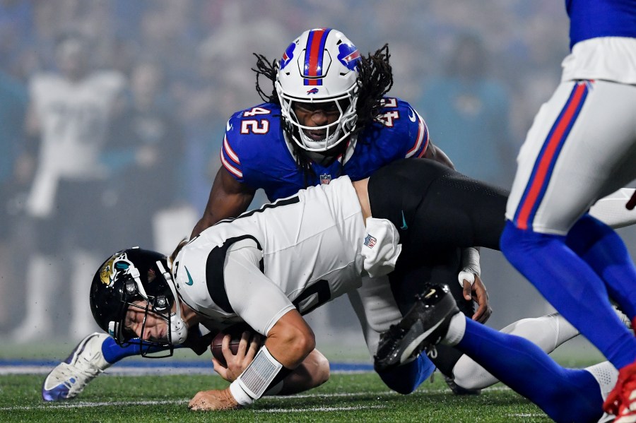 Jacksonville Jaguars quarterback Trevor Lawrence (16) lunges for yardage under Buffalo Bills linebacker Dorian Williams (42) during the first half of an NFL football game against the Buffalo Bills, Monday, Sept. 23, 2024, in Orchard Park, NY. (AP Photo/Adrian Kraus)