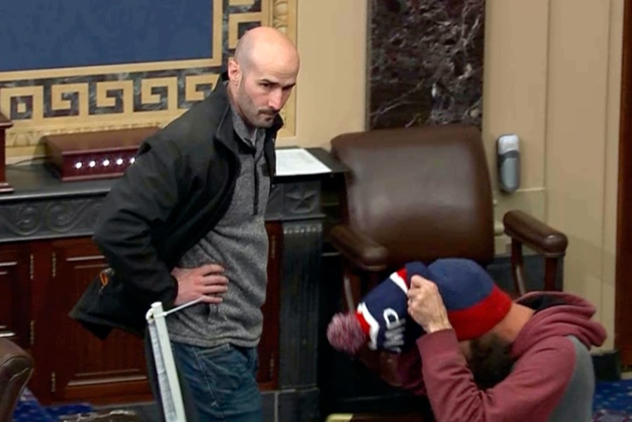 In this image from Senate Television, Leo Christopher Kelly, walks on the floor in the Senate chamber Jan. 6, 2021, at the U.S. Capitol in Washington. The federal Bureau of Prisons mistakenly released Kelly from custody before he finished serving his 30-month sentence for storming the Senate chamber during a mob's attack on the U.S. Capitol, Justice Department prosecutors said in a court filing. (Senate Television via AP)