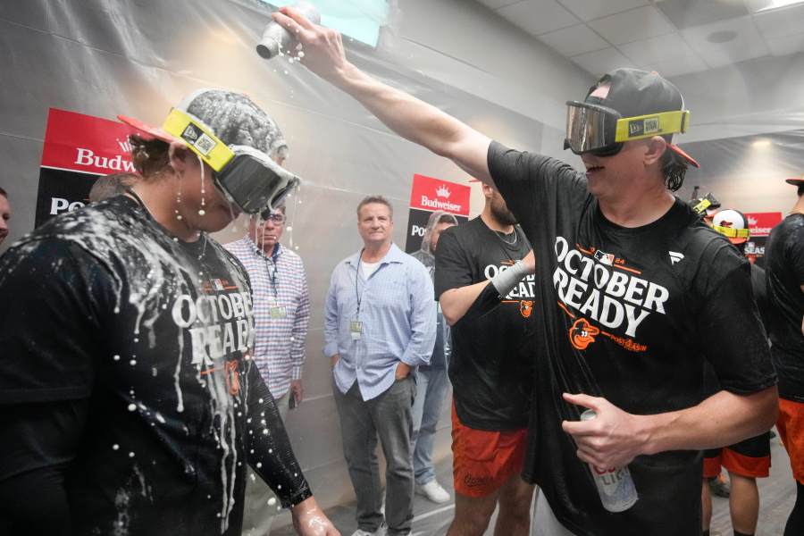 Baltimore Orioles' Jackson Holliday is doused with beer as teammates celebrate after clinching a playoff berth by defeating the New York Yankees in baseball game, Tuesday, Sept. 24, 2024, in New York. (AP Photo/Bryan Woolston)