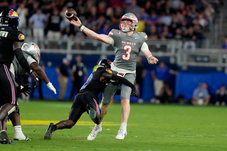 UNLV quarterback Matthew Sluka (3) passes as he is hit by Kansas cornerback Cobee Bryant (2) in the second half of an NCAA college football game Friday, Sept. 13, 2024, at Children's Mercy Park in Kansas City, Kan. (AP Photo/Ed Zurga)