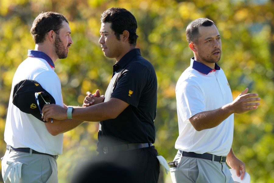 International team member Hideki Matsuyama of Japan shakes hands with United States team members Russell Henley, left, and Xander Schauffele, right, after winning their second round foursome match 7&6 at the Presidents Cup golf tournament at Royal Montreal Golf Club Friday, Sept. 27, 2024 in Montreal. (Frank Gunn/The Canadian Press via AP)