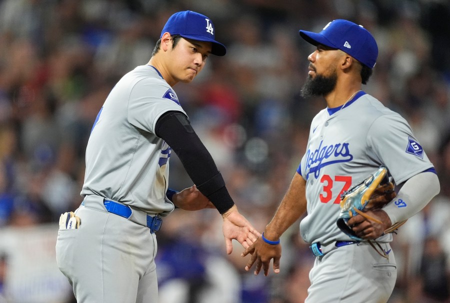 Los Angeles Dodgers' Shohei Ohtani, left, congratulates left fielder Teoscar Hernández after the Dodgers' victory over the Colorado Rockies in a baseball game, Friday, Sept. 27, 2024, in Denver. (AP Photo/David Zalubowski)