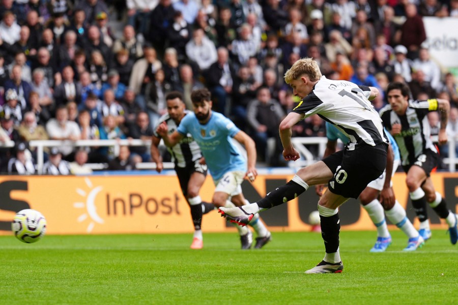 Newcastle United's Anthony Gordon shoots to score the equalizing goal from a penalty spot during the Premier League match between Newcastle and Manchester City, at St James' Park, Newcastle upon Tyne, England, Saturday Sept. 28, 2024. (Owen Humphreys/PA via AP)