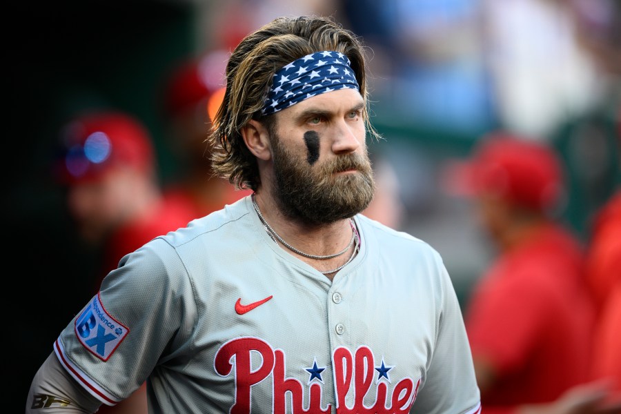 Philadelphia Phillies' Bryce Harper looks on from the dugout before a baseball game against the Washington Nationals, Saturday, Sept. 28, 2024, in Washington. (AP Photo/Nick Wass)