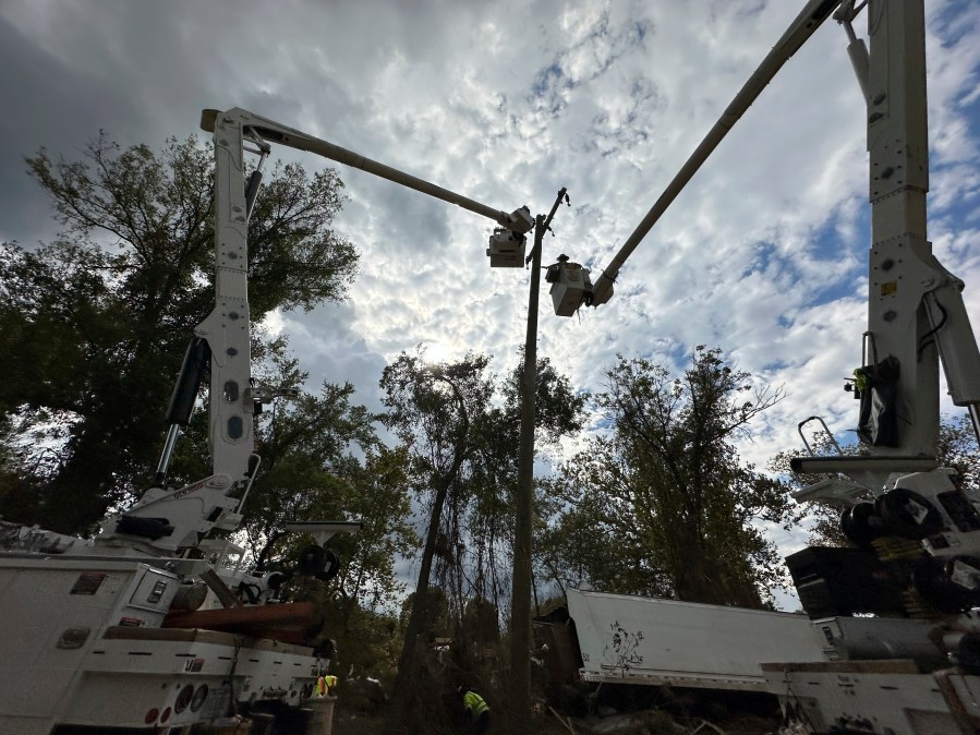 Contractors for Duke Energy rebuild destroyed electrical lines near the Swannanoa River in Asheville, N.C., Friday, Oct. 4, 2024. (AP Photo/Jeff Amy)