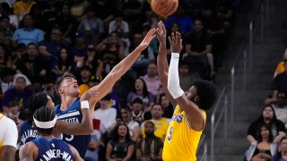 CORRECTS TO PALM DESERT, CALIF., NOT LOS ANGELES - Los Angeles Lakers guard Bronny James, right, shoots as Minnesota Timberwolves center Luka Garza defends during the first half of a preseason NBA basketball game, Friday, Oct. 4, 2024, in Palm Desert, Calif. (AP Photo/Mark J. Terrill)