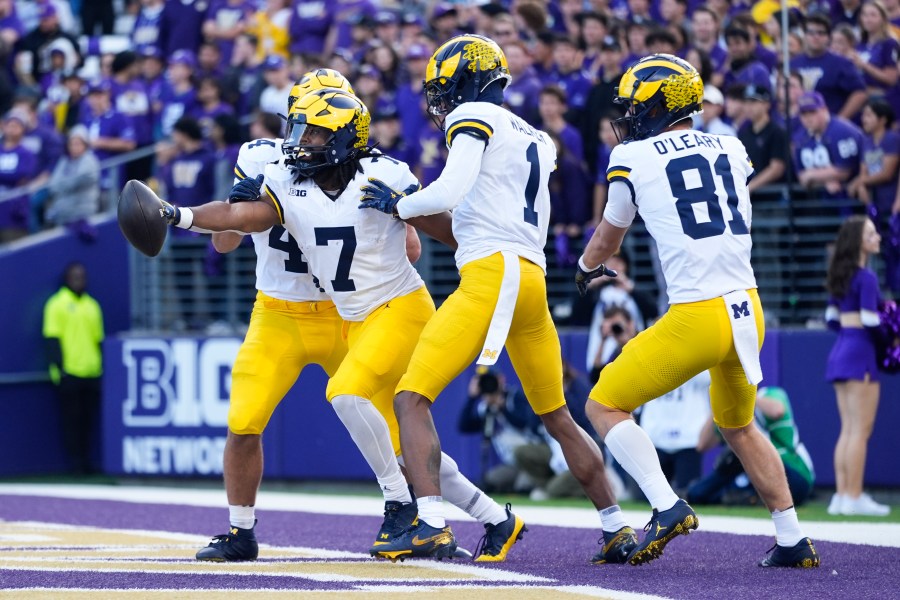 Michigan running back Donovan Edwards (7) reacts with wide receiver Amorion Walker (1) and wide receiver Peyton O'Leary (81) after scoring a touchdown against Washington during the first half of an NCAA college football game Saturday, Oct. 5, 2024, in Seattle. (AP Photo/Lindsey Wasson)