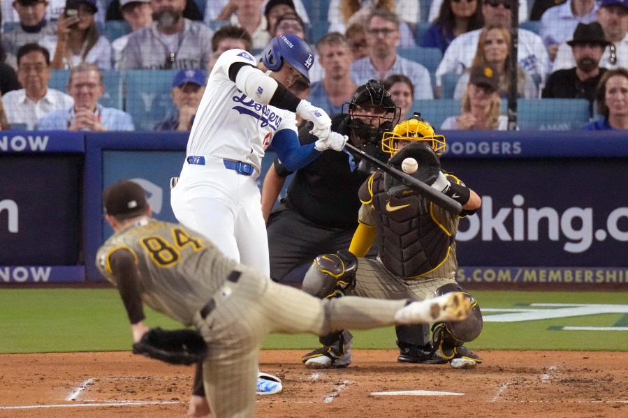 Los Angeles Dodgers' Shohei Ohtani, middle left, connects for a three-run home run off San Diego Padres starting pitcher Dylan Cease (84) during the second inning in Game 1 of baseball's NL Division Series, Saturday, Oct. 5, 2024, in Los Angeles. (AP Photo/Mark J. Terrill)