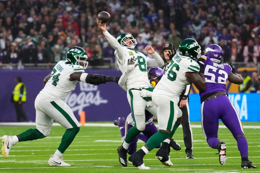 New York Jets quarterback Aaron Rodgers (8), second from left, throws while under pressure during the second half of an NFL football game against the Minnesota Vikings, Sunday, Oct. 6, 2024, at the Tottenham Hotspur stadium in London. (AP Photo/Kirsty Wigglesworth)