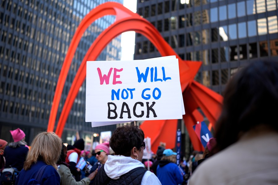 A woman holds a sign during National Women's March in Chicago, Saturday, Nov. 2, 2024. (AP Photo/Nam Y. Huh)