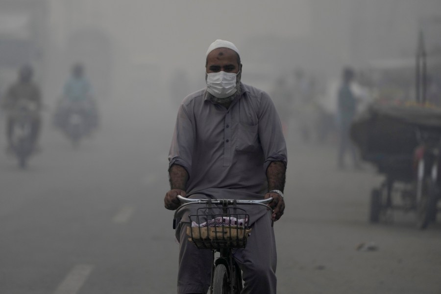 A cyclist, wearing mask, heads to his workplace as smog envelops the areas of Lahore, Pakistan, Wednesday, Nov. 6, 2024. (AP Photo/K.M. Chaudary)