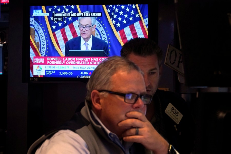 A pair of traders work on the floor of the New York Stock Exchange, Thursday, Nov. 7, 2024, in New York, as Federal Reserve Chair Jerome Powell news conference in Washington is displayed on a monitor. (AP Photo/Richard Drew)