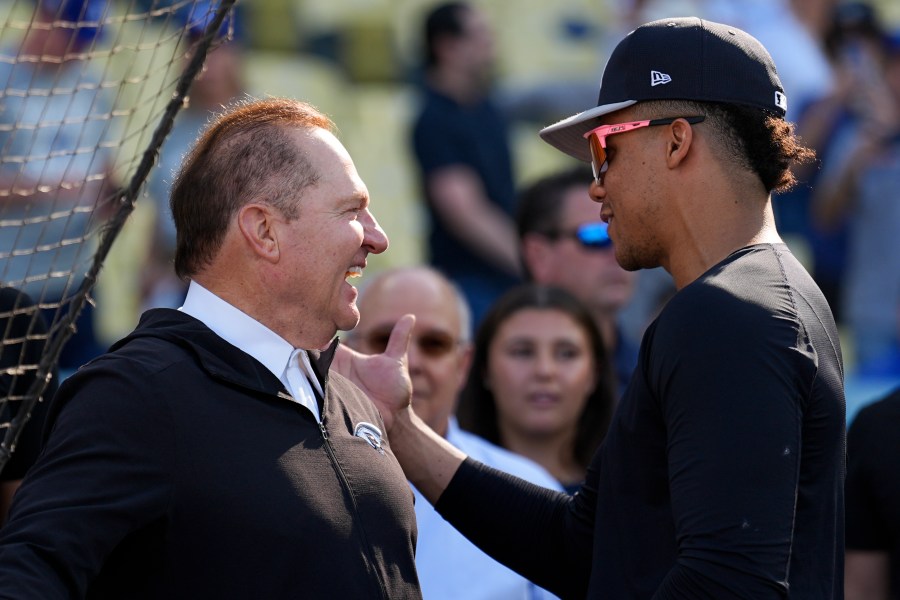 New York Yankees' Juan Soto talks with agent Scott Boras before Game 1 of the baseball World Series against the Los Angeles Dodgers, Friday, Oct. 25, 2024, in Los Angeles. (AP Photo/Julio Cortez)