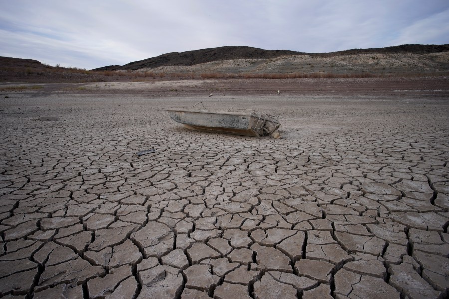 FILE - A formerly sunken boat sits on cracked earth hundreds of feet from the shoreline of Lake Mead at the Lake Mead National Recreation Area on May 10, 2022, near Boulder City, Nev. (AP Photo/John Locher, File)