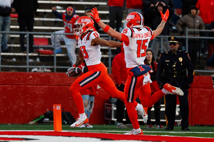 Illinois wide receiver Pat Bryant (13) scores a 40-yard touchdown after making a catch as teammate Alexander Capka-Jones (15) celebrates in the final seconds of an NCAA college football game against Rutgers, Saturday, Nov. 23, 2024, in Piscataway, N.J. Illinois defeated Rutgers 38-31. (AP Photo/Rich Schultz)