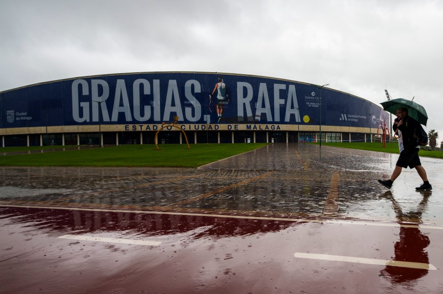 A man walks in front a banner reading in Spanish: "Thank you Rafa" during the Billie Jean King Cup finals at the Martin Carpena sportshall in Malaga, southern Spain, Wednesday, Nov. 13, 2024, after today's matches were canceled due to heavy rain and postponed until tomorrow. (AP Photo/Manu Fernandez)