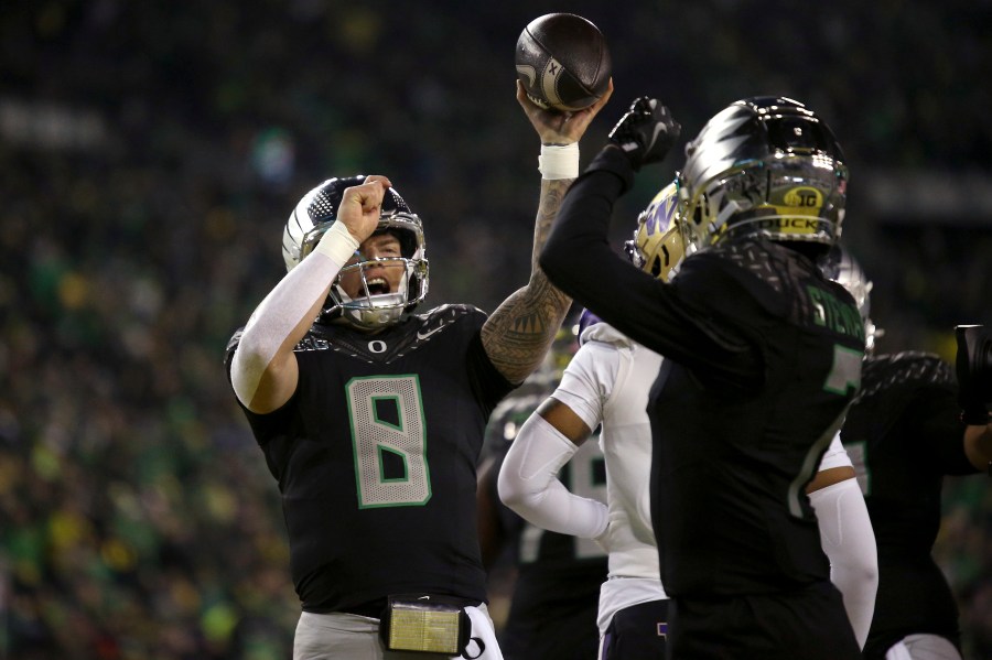 Oregon quarterback Dillon Gabriel (8) and Oregon wide receiver Evan Stewart (7) celebrate after Gabriel's touchdown during an NCAA college football game against Washington, Saturday, Nov. 30, 2024, in Eugene, Ore. (AP Photo/Lydia Ely)