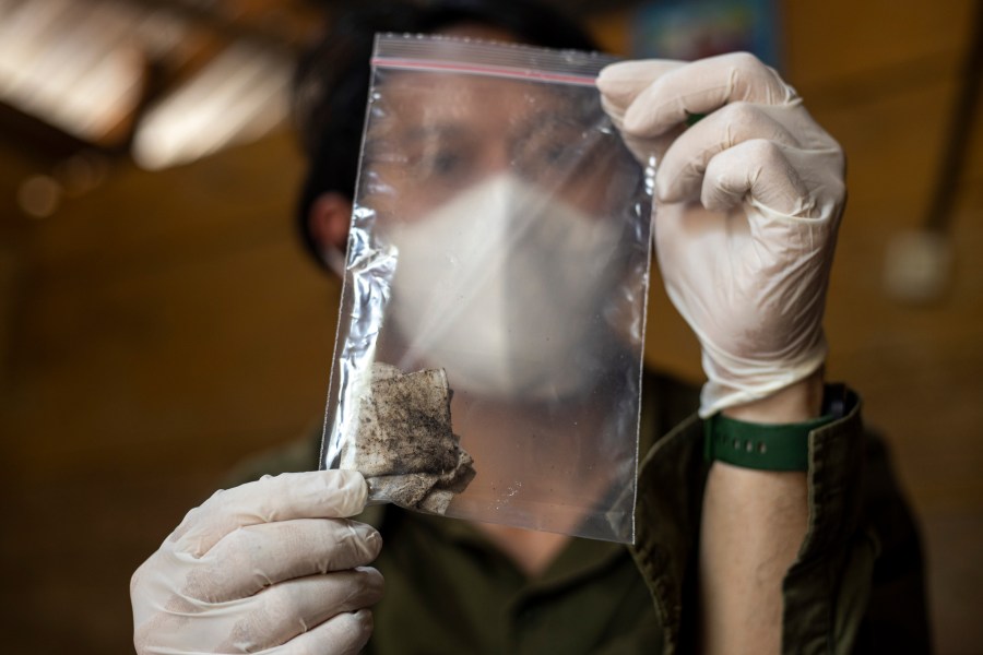 Dhany Alfalah, a researcher with Satya Bumi, a nonprofit environmental organization, shows dust samples collected from a house on Kabaena Island, Indonesia, Friday, Nov. 15, 2024. (AP Photo/Yusuf Wahil)