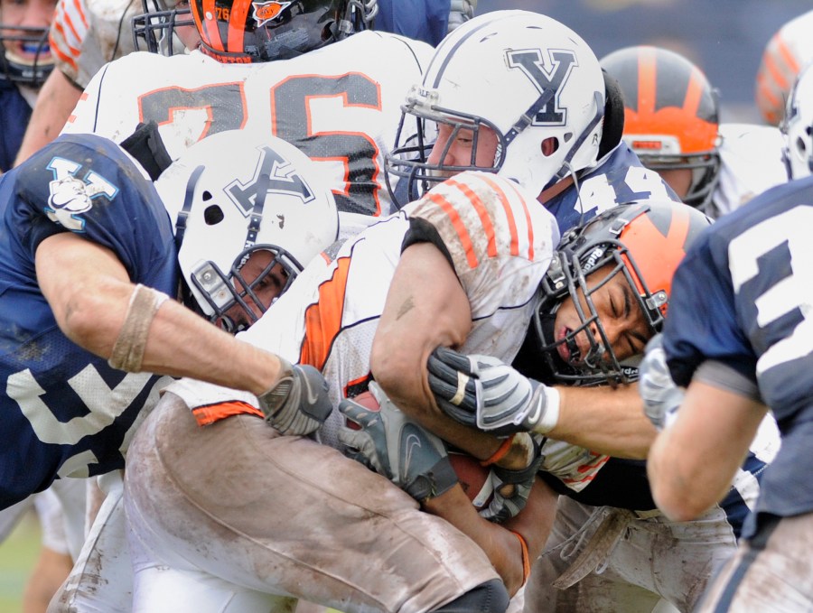 FILE - Princeton's Jordan Culbreath, center, fights for an extra yard as he is tackled by Yale's Jay Pilkerton, left, Bobby Abare, center, and Brady Hart, right during Yale's 14-0 victory in an NCAA college football game in New Haven, Conn., on Saturday, Nov. 15, 2008. (AP Photo/Fred Beckham, File)