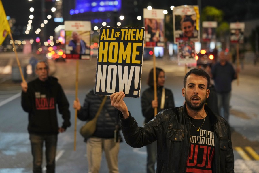 FILE - Israeli protesters outside the Ministry of Defense headquarters in Tel Aviv, Israel, call for Hamas to release hostages on Tuesday, Dec. 17, 2024. (AP Photo/Ariel Schalit, File)