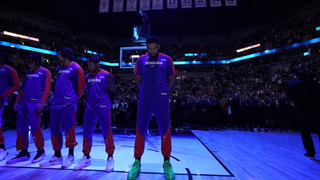 New York Knicks center Karl-Anthony Towns, center, stands on the court as the national anthem is played before an NBA basketball game against the Minnesota Timberwolves, Thursday, Dec. 19, 2024, in Minneapolis. (AP Photo/Abbie Parr)