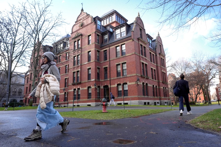 People walk between buildings, Tuesday, Dec. 17, 2024, on the campus of Harvard University in Cambridge, Mass. (AP Photo/Steven Senne)