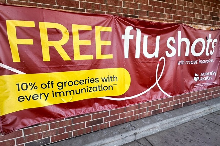 FILE - A sign for flu vaccination is displayed outside of a grocery store in Glenview, Ill., Thursday, Feb. 15, 2024. (AP Photo/Nam Y. Huh, File)