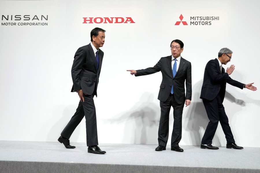 Nissan Chief Executive Makoto Uchida, left, Takao Kato, CEO of Mitsubishi Motors, center, and Honda Chief Executive Toshihiro Mibe, right, leave after a joint news conference in Tokyo, Japan, Monday, Dec. 23, 2024. (AP Photo/Eugene Hoshiko)