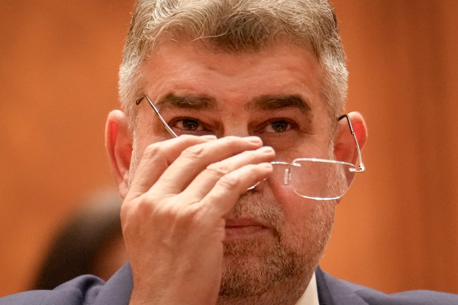 Romanian Prime Minister designate Marcel Ciolacu, the leader of the Social Democratic party, adjusts his glasses before a confidence vote for him and his team at the parliament in Bucharest, Romania, Monday, Dec. 23, 2024. (AP Photo/Vadim Ghirda)