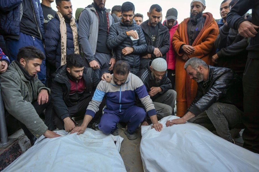 Palestinians mourn over the bodies of five policemen killed Monday by an Israeli strike in Deir al-Balah, central Gaza Strip, Tuesday Dec. 24, 2024. According to witnesses at the scene, the policemen fired shots to prevent a group of bandits blocking the road from stealing aid from a truck. The Israeli army immediately struck the policemen after that.(AP Photo/Abdel Kareem Hana)