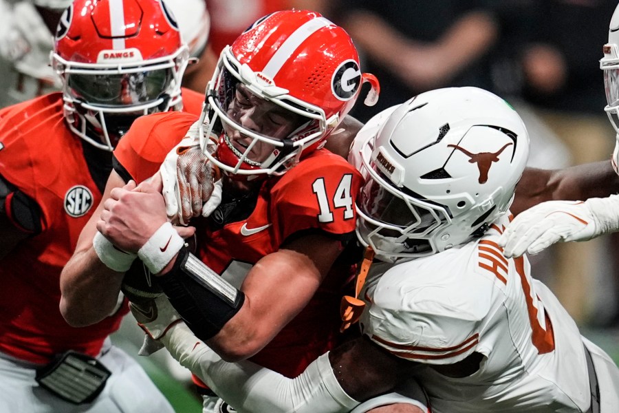 Texas linebacker Anthony Hill Jr. (0) hits Georgia quarterback Gunner Stockton (14) during the second half of the Southeastern Conference championship NCAA college football game, Saturday, Dec. 7, 2024, in Atlanta. (AP Photo/Mike Stewart)